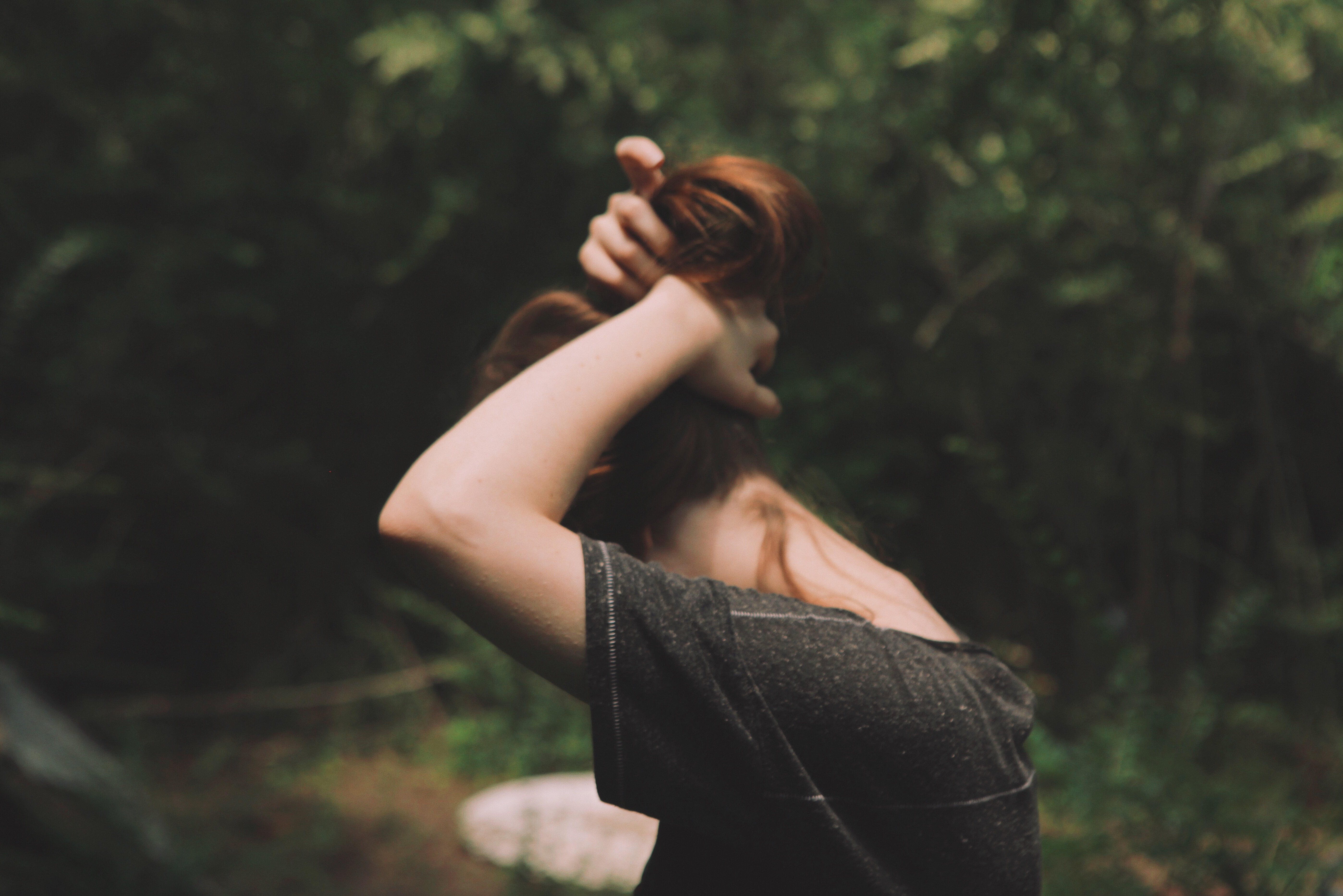 female pulling hair up into a ponytail