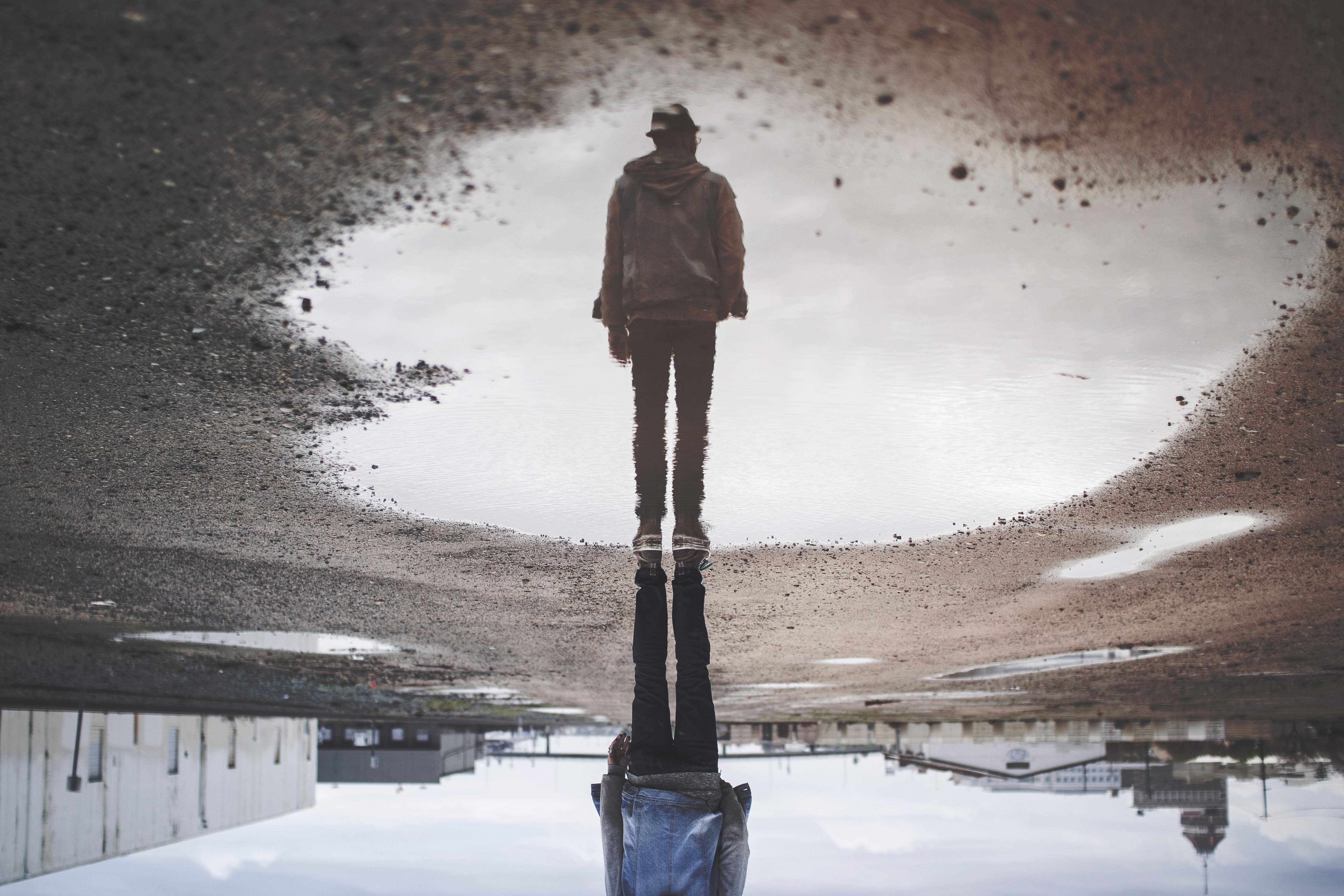 Man standing by puddle with reflection